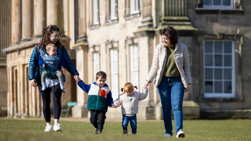 Family walking in a line with a view of the house in the background